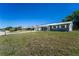 A single-story home sits on a verdant lot underneath a clear blue sky at 1199 Galgano Ave, Deltona, FL 32725
