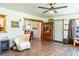 Inviting living room with wood-look flooring, a ceiling fan, and a comfortable armchair at 1199 Galgano Ave, Deltona, FL 32725