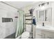 Bathroom features a shower with a marble tile surround, modern vanity, and decorative shelves at 1265 Aquarius Ave, Deland, FL 32724