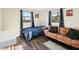 Bedroom boasts dark wood floors, a futon, a comfortable bed, and natural lighting at 1265 Aquarius Ave, Deland, FL 32724