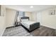 Bedroom with a tufted gray bed, dark wood floors, and a patterned rug at 1265 Aquarius Ave, Deland, FL 32724