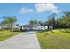Landscaped front yard with a long drive leading to a home with trees offering shade in the yard at 1265 Aquarius Ave, Deland, FL 32724