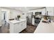 Bright kitchen with stainless steel appliances, white cabinets, island, and dark wood flooring at 1265 Aquarius Ave, Deland, FL 32724