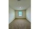 This bedroom features neutral carpet, a window, and overhead lighting at 131 Reena Dr, Daytona Beach, FL 32117