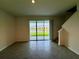 Sunlit living room with large sliding glass doors overlooking a serene pond and backyard at 131 Reena Dr, Daytona Beach, FL 32117