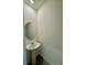 Compact powder room with a pedestal sink, oval mirror, and neutral wall color at 131 Reena Dr, Daytona Beach, FL 32117