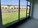 Screened-in patio with views of a pond and green lawn extending to the neighboring townhomes at 131 Reena Dr, Daytona Beach, FL 32117