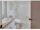 Bright white bathroom featuring a sink, toilet, and walk-in shower at 1320 Bakersfield Ave, Deltona, FL 32725