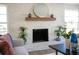 Bright living room with a white brick fireplace and wooden mantle decorated with plants and ornaments at 140 E Faith Ter, Maitland, FL 32751