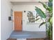 Welcoming front entrance with an orange door and lush tropical foliage at 140 E Faith Ter, Maitland, FL 32751
