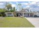 Charming home with a well-manicured lawn, carport and inviting curb appeal, and lush tropical landscaping at 140 E Faith Ter, Maitland, FL 32751