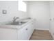 Bright laundry room with a sink, new floors and clean white cabinets at 140 E Faith Ter, Maitland, FL 32751