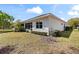 Back exterior showcasing the yard, mature landscaping, and a screened-in patio for outdoor enjoyment at 1422 Carlow Cir, Ormond Beach, FL 32174