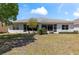 Backyard view of home with a well-maintained lawn, lush landscaping, and a screened lanai at 1422 Carlow Cir, Ormond Beach, FL 32174