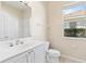Bright bathroom featuring a white vanity with crystal knobs, a toilet, and a window at 1422 Carlow Cir, Ormond Beach, FL 32174