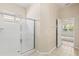 Bright bathroom featuring a tiled shower with a sliding glass door and an open doorway to the bedroom at 1422 Carlow Cir, Ormond Beach, FL 32174