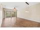 Open-concept living room boasts wood laminate flooring, a ceiling fan, and sliding glass doors at 1422 Carlow Cir, Ormond Beach, FL 32174