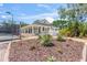 View of the clubhouse and surrounding tennis courts with nicely landscaped entrance and walkways at 1422 Carlow Cir, Ormond Beach, FL 32174