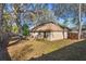 A large backyard with shade trees and a partial view of the exterior of the tan colored home at 1430 17Th St, Orange City, FL 32763