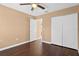 Bedroom features wood flooring, a ceiling fan, double closets, and a door, providing ample storage and easy access to other areas at 1430 17Th St, Orange City, FL 32763
