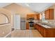Well-lit kitchen featuring stainless steel appliances, wooden cabinets, tile flooring, and a pantry with easy access to the dining area at 1430 17Th St, Orange City, FL 32763