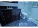 This elegant bathroom features a dark vanity, toilet and modern glass shower at 1533 Legend Ct, Deltona, FL 32738