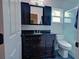 Bathroom features dark vanity and sink with modern toilet and tile-walled shower at 1533 Legend Ct, Deltona, FL 32738