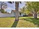 Home featuring a well-manicured lawn, white fence, and a mature shade tree at 1533 Legend Ct, Deltona, FL 32738