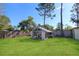 Backyard view showcasing a large greenhouse in a well-maintained yard at 1551 7Th Ave, Deland, FL 32724