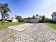 Home featuring a long driveway with stone accents, attached garage, and well-maintained landscaping at 1551 7Th Ave, Deland, FL 32724