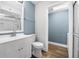 A modern bathroom features blue accent walls, a sleek vanity and a glass-enclosed shower at 171 Moonstone Ct, Port Orange, FL 32129