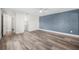 A large bedroom features hardwood floors, blue accent wall and a view into the bathroom at 171 Moonstone Ct, Port Orange, FL 32129