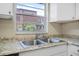 A well-lit kitchen features a stainless steel sink, granite countertops and a window overlooking the exterior at 171 Moonstone Ct, Port Orange, FL 32129