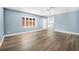 Sunlit living area with sleek laminate flooring, updated ceiling fan, and a view of the home's kitchen at 171 Moonstone Ct, Port Orange, FL 32129
