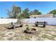 Backyard featuring a fire pit and benches surrounded by grass and a white fence at 1767 Valencia Ave, Ormond Beach, FL 32174