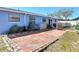 Charming backyard with brick patio, plants, and a blue exterior of the house visible at 1767 Valencia Ave, Ormond Beach, FL 32174