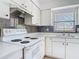 Bright kitchen features white cabinetry, stainless steel sink and tiled backsplash at 1767 Valencia Ave, Ormond Beach, FL 32174