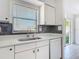 This kitchen has a stainless steel sink and white cabinets and countertops at 1767 Valencia Ave, Ormond Beach, FL 32174