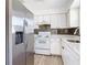 Modern kitchen featuring stainless steel appliances, white cabinets, and stone countertops at 1767 Valencia Ave, Ormond Beach, FL 32174