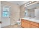 Well-lit bathroom featuring a white door leading outside, toilet and a vanity with storage at 1877 N Merrick Dr # 0, Deltona, FL 32738