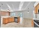 Kitchen with stainless steel appliances, wooden cabinets, tile floor, and open layout into dining area at 1877 N Merrick Dr # 0, Deltona, FL 32738