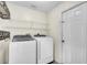 Bright laundry room with Samsung washer and dryer plus storage shelves and decorative ironwork at 1877 N Merrick Dr # 0, Deltona, FL 32738