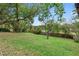 A grassy backyard with a wood fence perimeter and mature trees providing a private setting at 1880 N Merrick Dr, Deltona, FL 32738