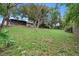 Expansive backyard with a lush green lawn and mature trees providing ample shade at 1880 N Merrick Dr, Deltona, FL 32738