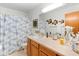 Bright bathroom featuring a shower with patterned curtains and lots of counter space at 1880 N Merrick Dr, Deltona, FL 32738