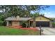 Charming one-story home with a well-maintained front yard, mature trees, and a brick and siding facade at 1880 N Merrick Dr, Deltona, FL 32738