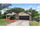 Charming one-story home with a well-maintained front yard, mature trees, and a brick and siding facade at 1880 N Merrick Dr, Deltona, FL 32738