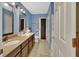 Full bathroom with double vanity, tile floor, decorative mirrors, and a walk-in shower at 1963 Stacey Cir, Deltona, FL 32738