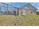 Exterior side view of home with a screened-in patio and an outdoor entrance at 1963 Stacey Cir, Deltona, FL 32738