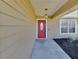 Charming front entrance featuring a red door, covered porch, and well-maintained landscaping at 1963 Stacey Cir, Deltona, FL 32738